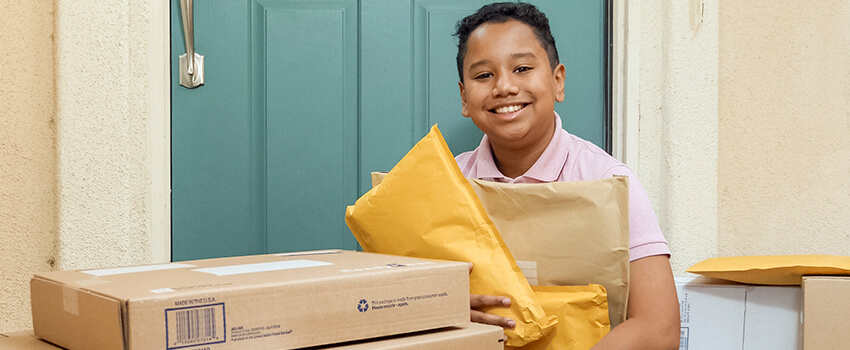 a kid in front of the door with some packages